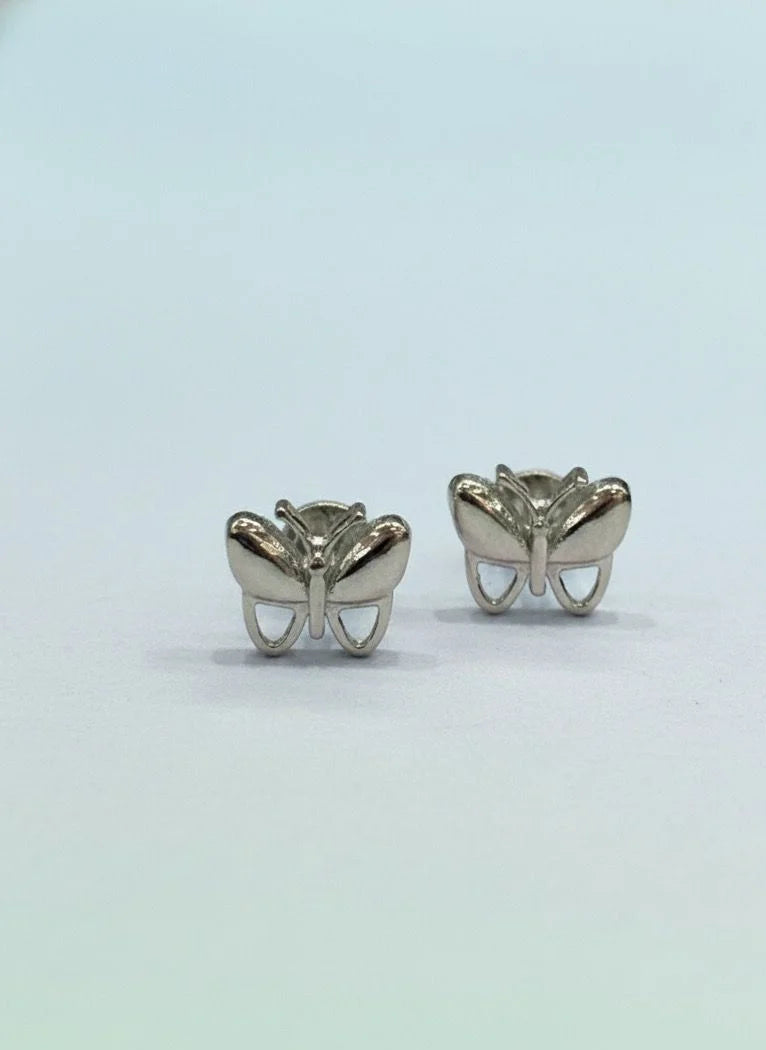 Butterfly-shaped silver earrings on a light gray background