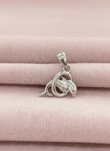 Silver dolphin pendant on a pink fabric background