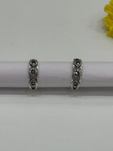 Pair of silver toe rings with black stones on a white background