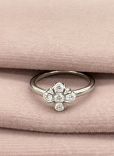 Silver ring with clover on a pink fabric background