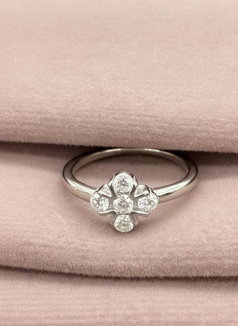 Silver ring with clover on a pink fabric background