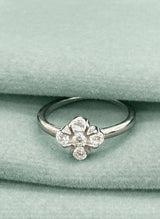 Silver ring with floral design on a green velvet surface