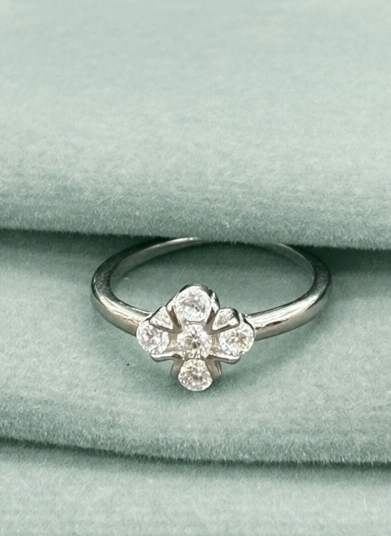 Silver ring with floral design on a green velvet surface