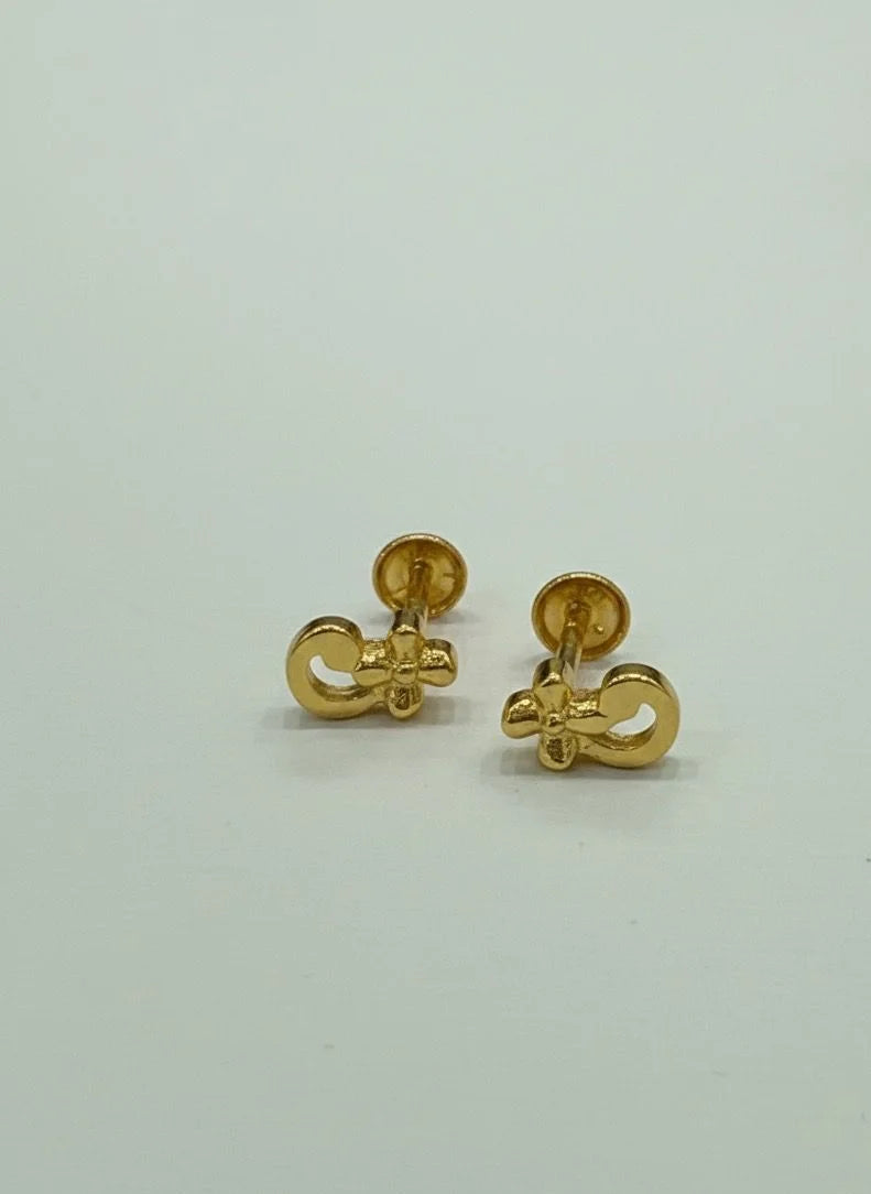 Pair of gold earrings on a light gray background