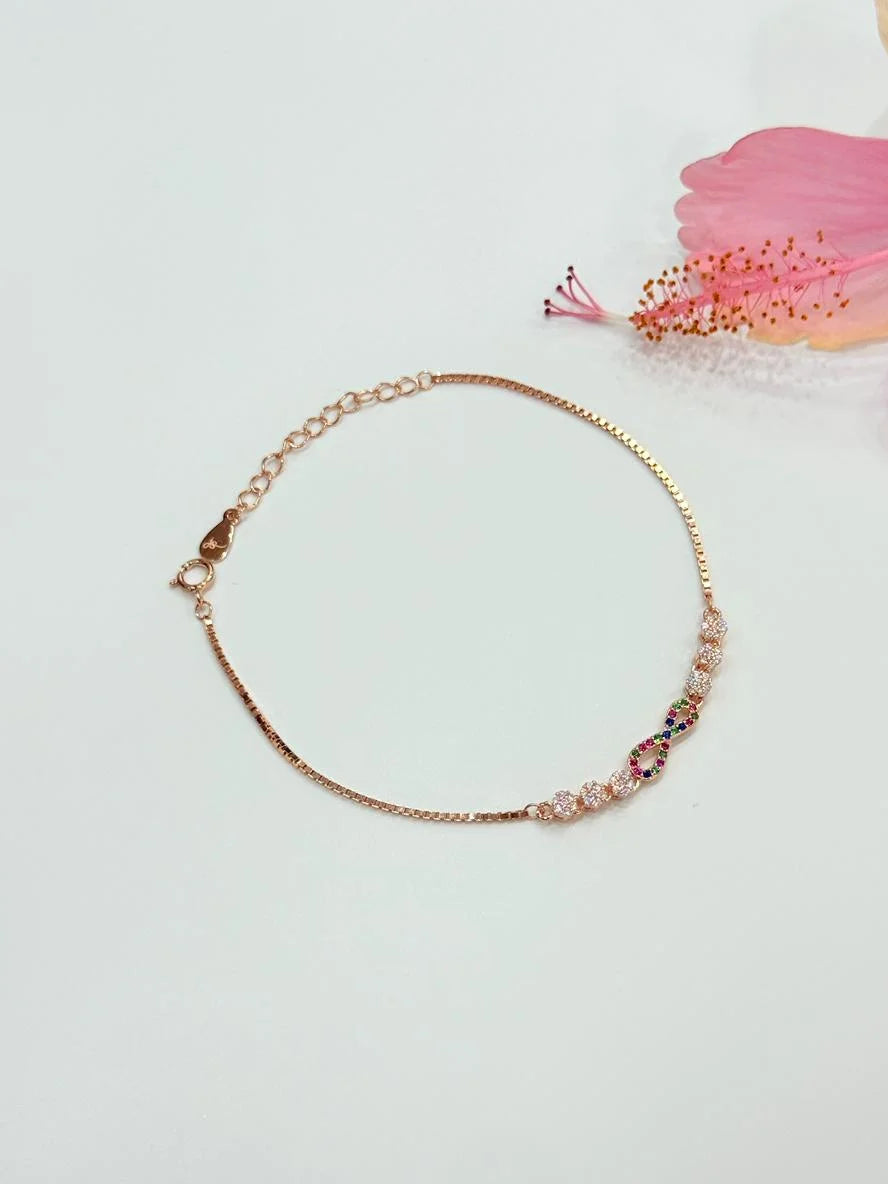 Gold bracelet with colorful beads on a light background