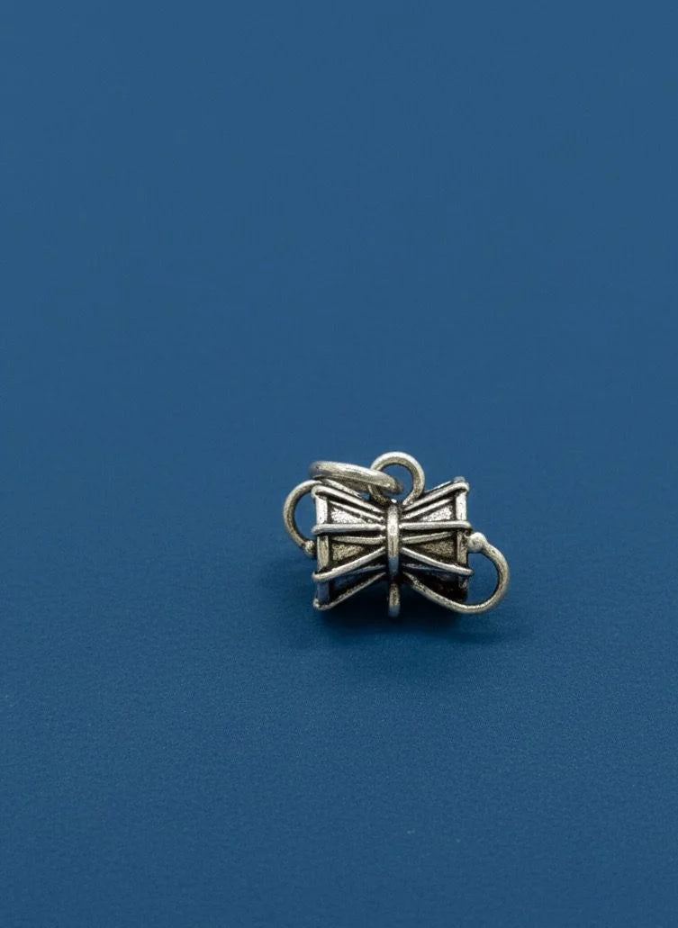 Silver bow-shaped charm on a blue background