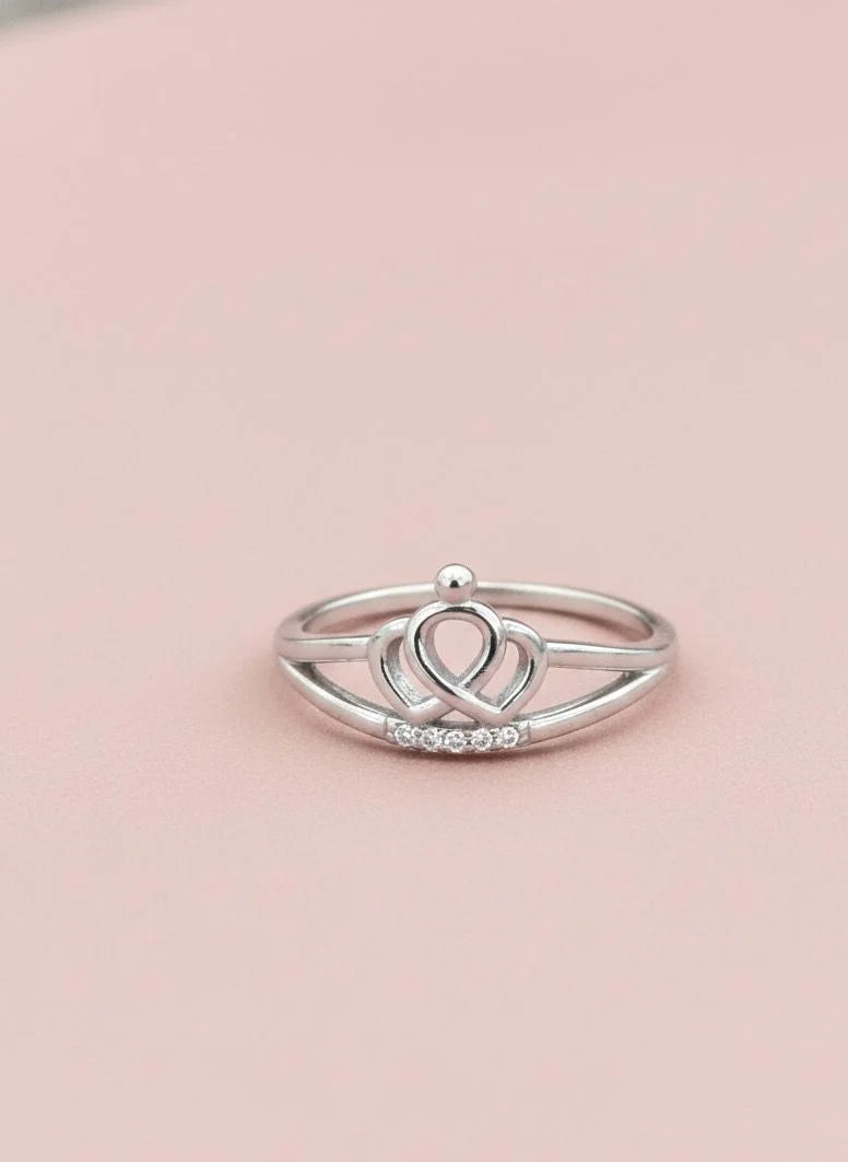 Silver ring with a unique design on a pink background