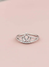 Silver ring with a unique design on a pink background