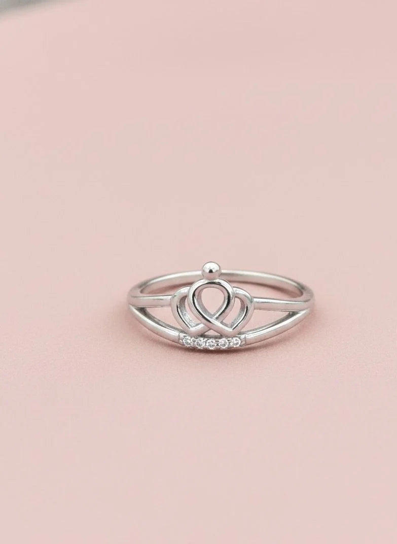 Silver ring with a unique design on a pink background