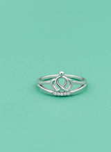 Silver ring with a heart design on a light green background