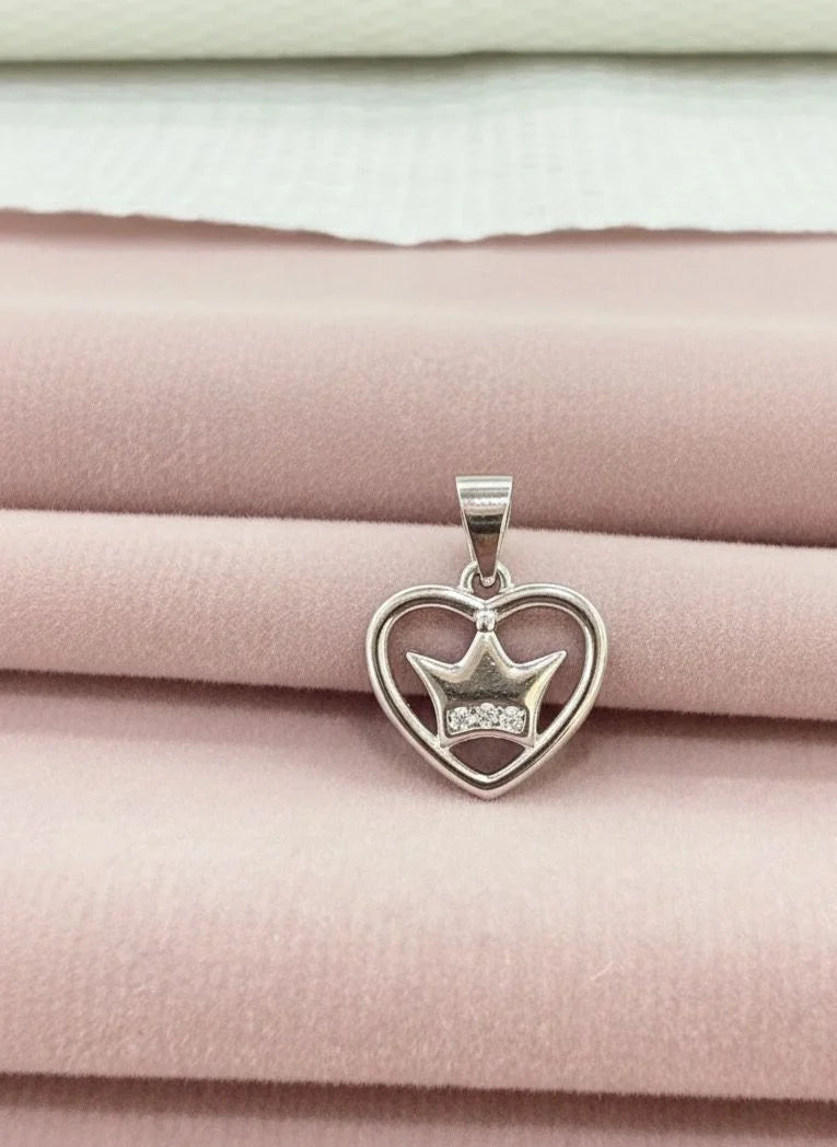 Silver heart-shaped pendant with a star design on a pink fabric background