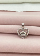 Silver heart-shaped pendant with a star design on a pink fabric background