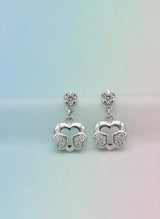 Silver earrings with heart designs on a gradient background