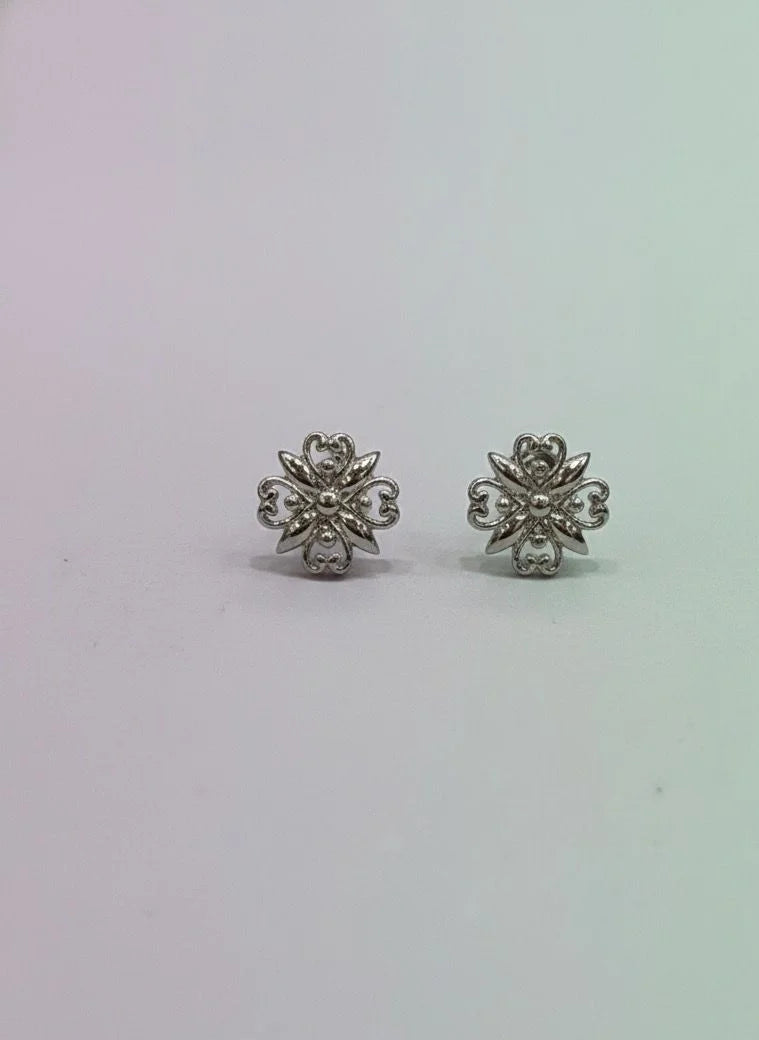 Pair of silver floral earrings on a light gray background