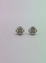 Pair of silver floral earrings on a light gray background