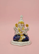 Decorative statue of a seated figure with colorful attire on a pink background