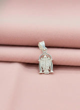 Silver pendant on a pink fabric background