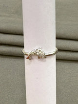 Silver dolphin ring on a white candle against a gray background