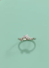 Silver ring with stone on a light green background