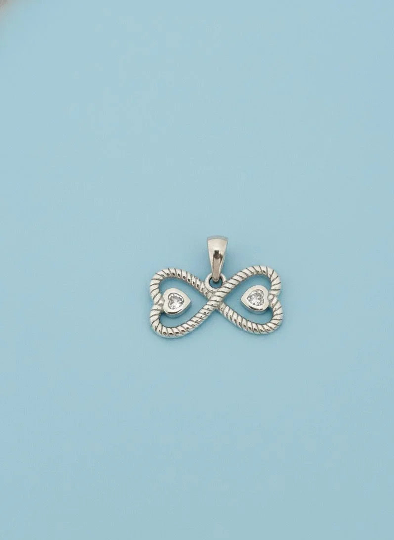 Silver infinity pendant with heart details on a light blue background