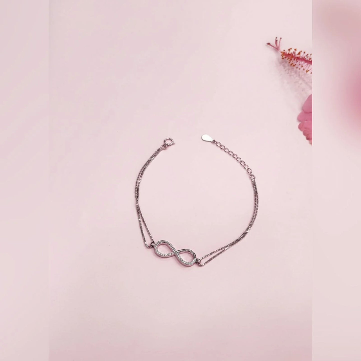 Silver bracelet with a unique design on a pink background