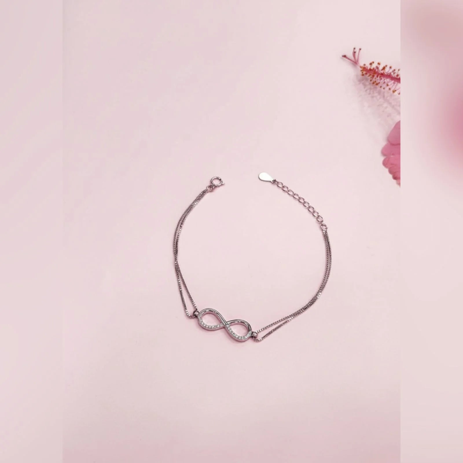 Silver bracelet with a unique design on a pink background