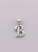Silver 'B' pendant on a light purple background