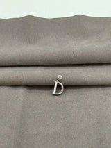 Silver 'D' pendant on a gray fabric background