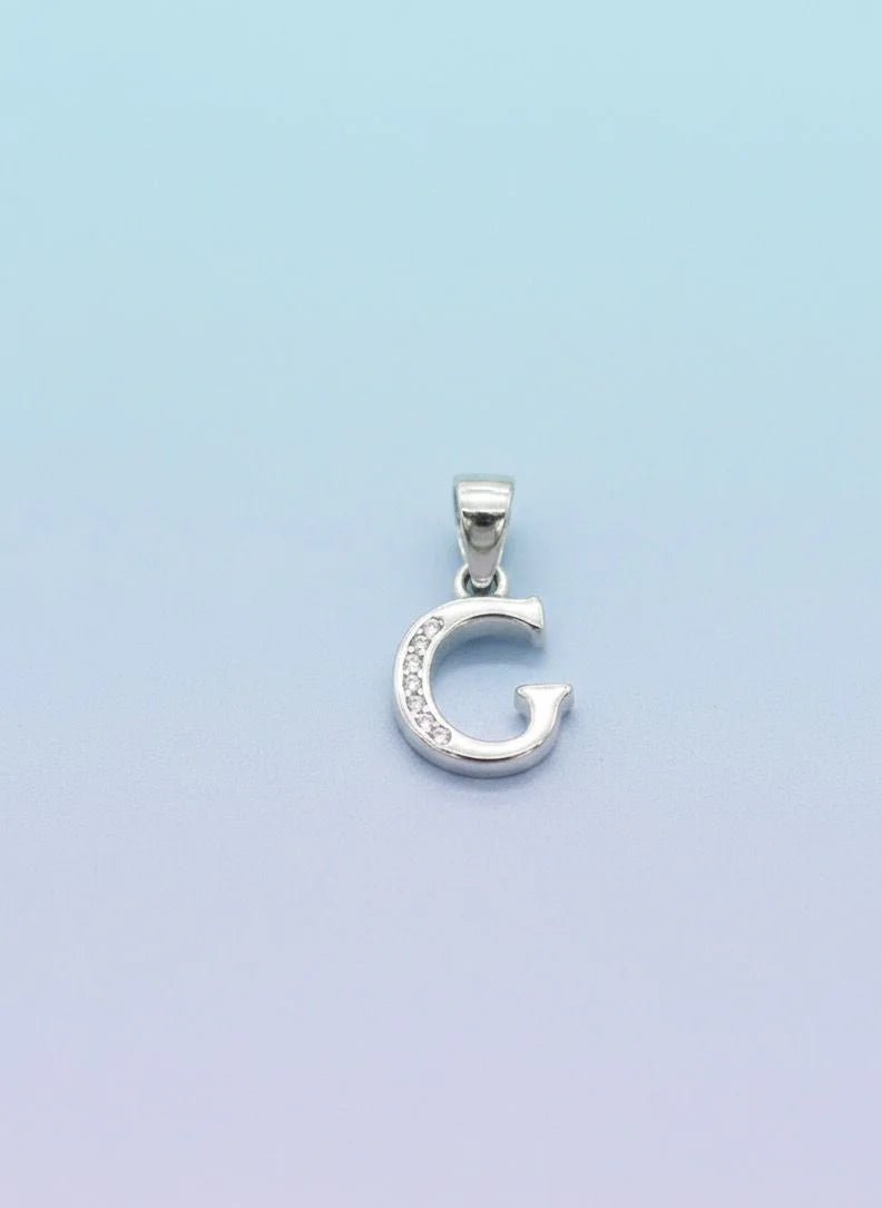 Silver 'G' pendant on a light blue background