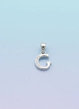 Silver 'G' pendant on a light blue background