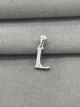 Silver 'L' pendant on a gray fabric background