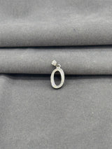 Silver pendant on a gray fabric background