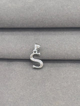 Silver 'S' pendant on a gray fabric background