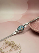 Silver bracelet with a heart-shaped clasp on a pink surface