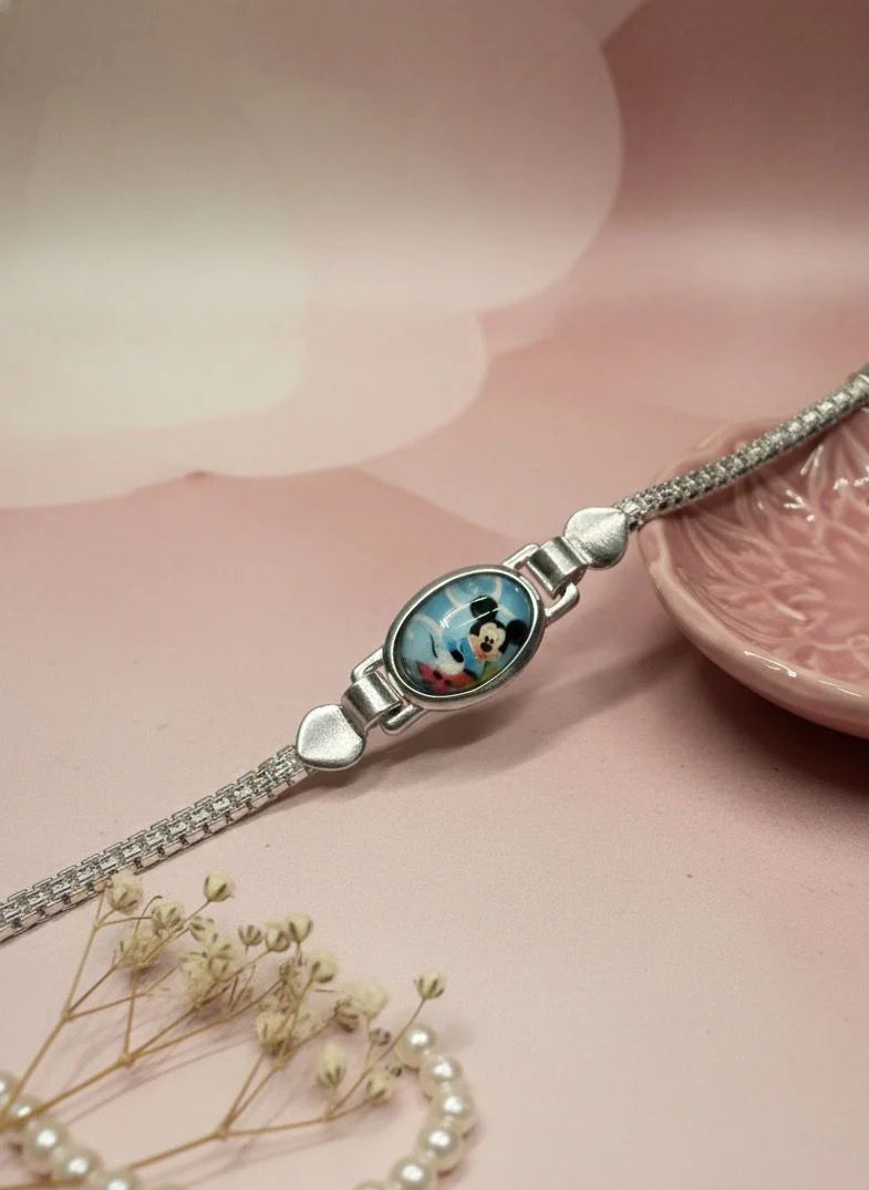 Silver bracelet with a heart-shaped clasp on a pink surface