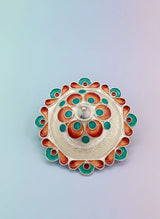 Decorative metal lid with colorful patterns on a light gradient background