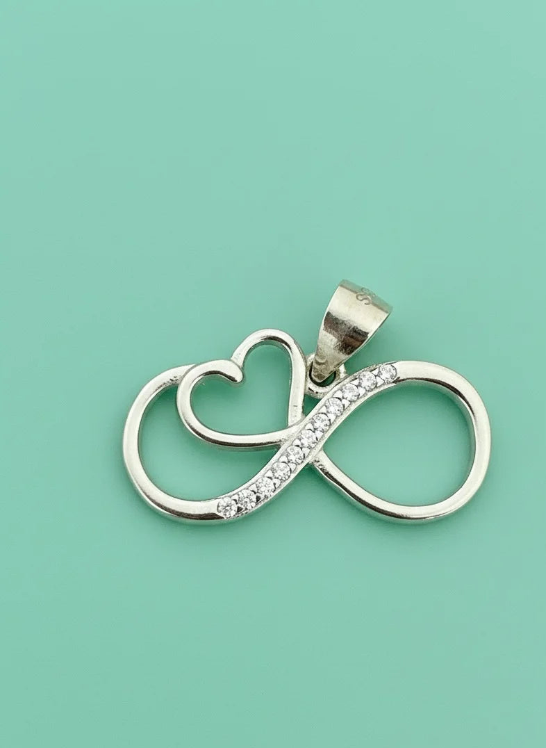 Silver pendant with infinity symbol and heart on a light green background