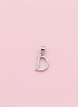 Silver 'D' pendant on a pink background