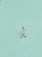 Silver 'N' pendant on a light blue background