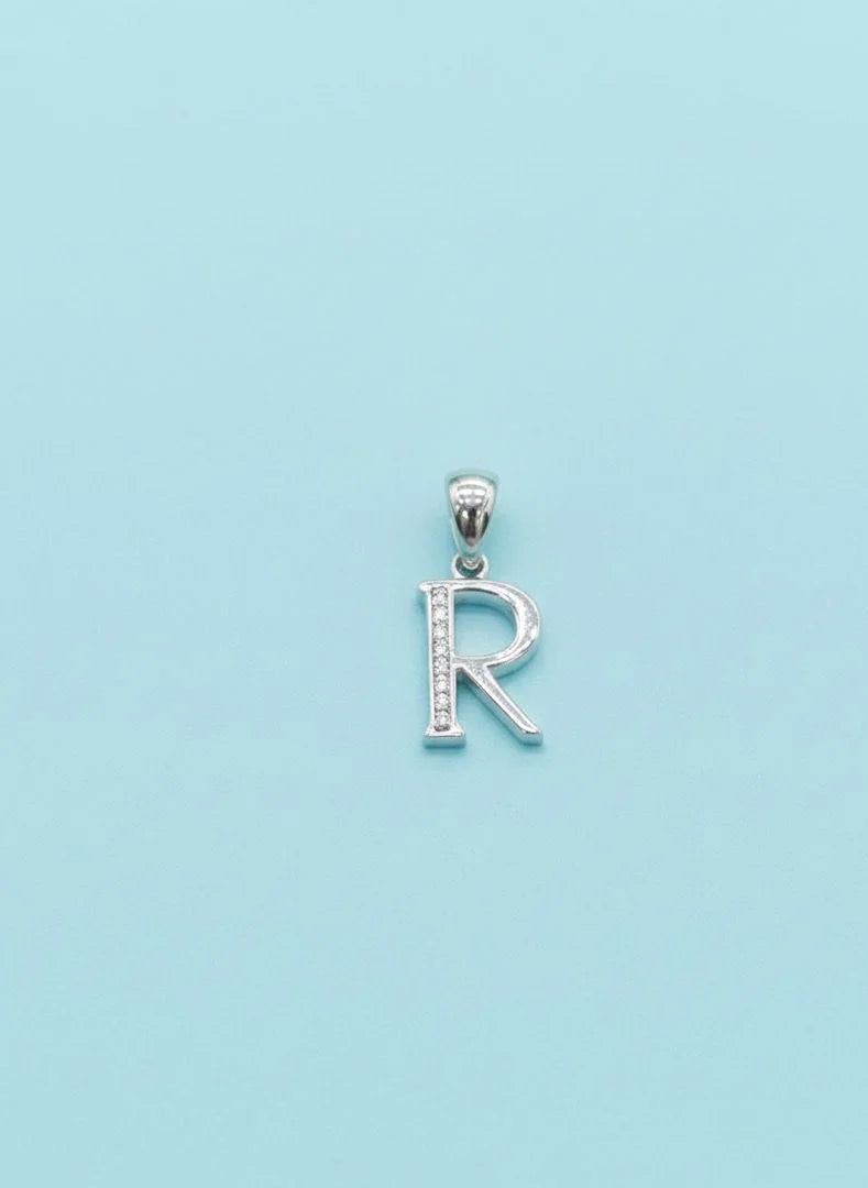Silver 'R' pendant on a light blue background