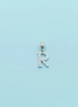 Silver 'R' pendant on a light blue background