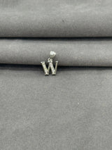 Silver 'W' pendant on a gray fabric background