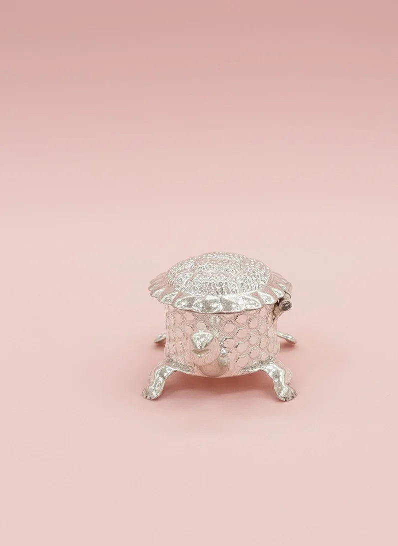 Silver decorative box on a pink background
