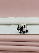 Black elephant figurine with decorative headpiece on fabric background