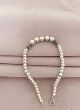 Silver ball bracelet on a pink fabric background