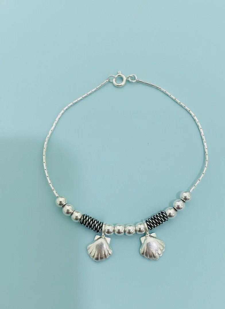 Bracelet with shell on a light blue background