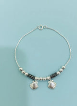 Bracelet with shell on a light blue background