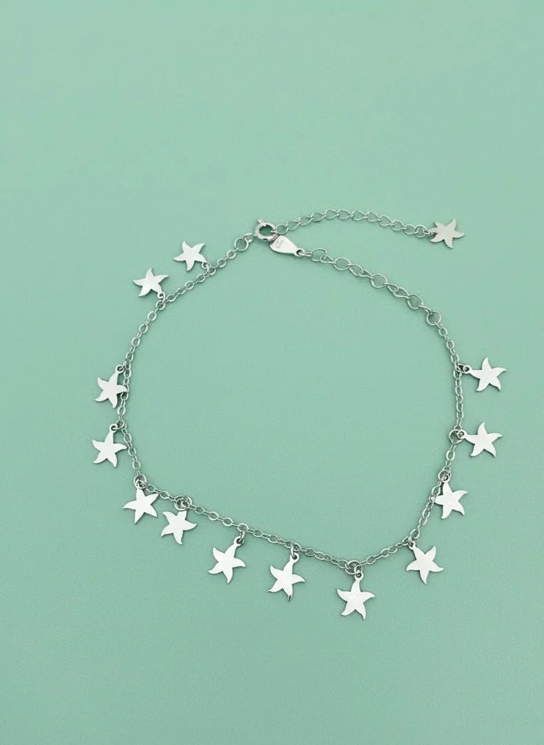 Silver star bracelet on a light green background