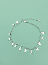 Silver star bracelet on a light green background