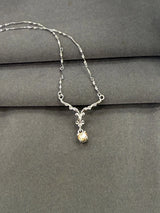 Silver necklace with a small pendant on a gray surface